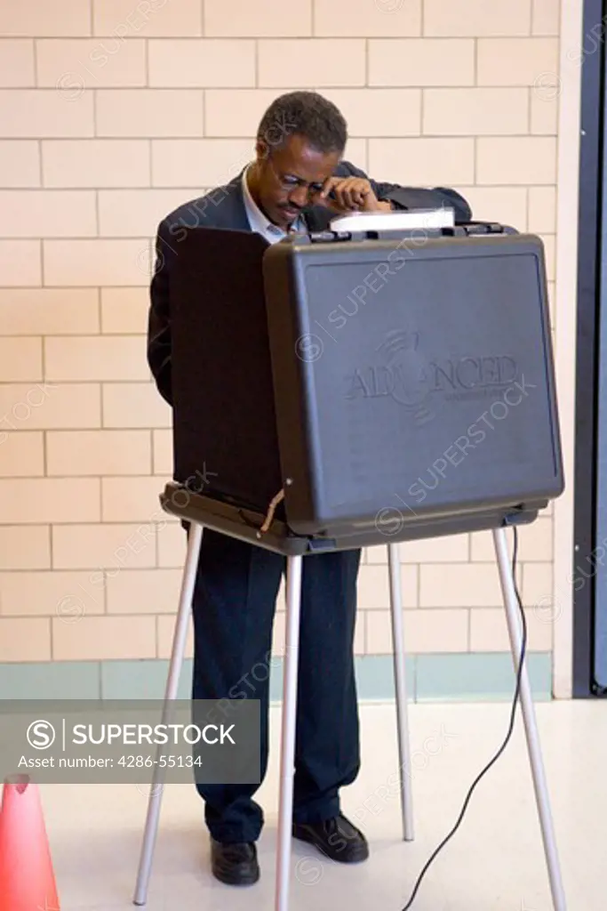 African-American voter casts ballot in presidential election, using touch screen machines in Arlington, Virginia. 