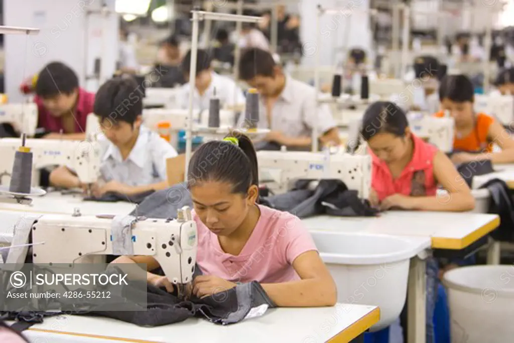 SHENZHEN, GUANGDONG PROVINCE, CHINA - Workers sewing Mango jeans, in garment factory in city of Shenzhen, one of mainland China's first Special Economic Zones, SEZ.