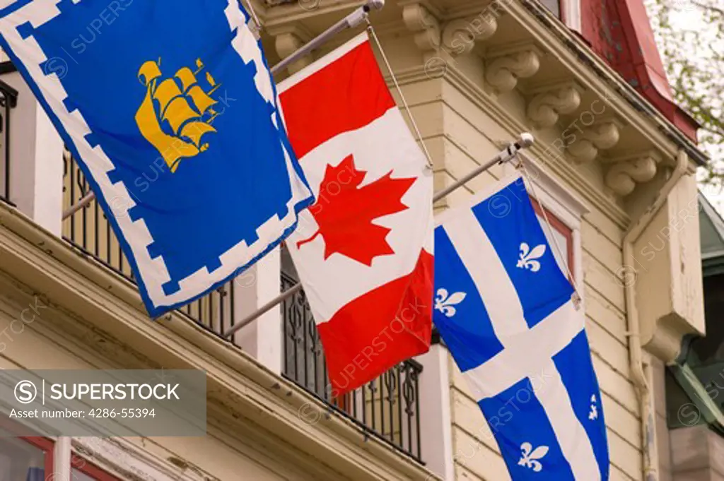 QUEBEC CITY, QUEBEC, CANADA - National and regional flags on display in Quebec City. Left to right: City of Quebec; Canada; Quebec.