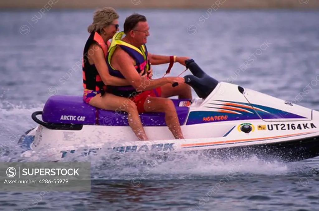 Mature couple riding jet-ski on Lake Powell, UT