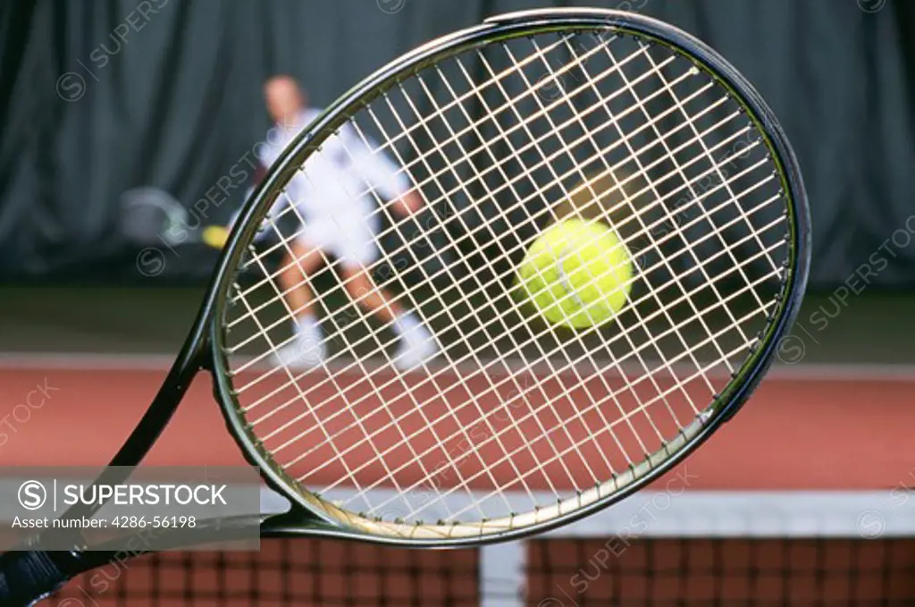 Tennis game, seen throught the racket of one player.  