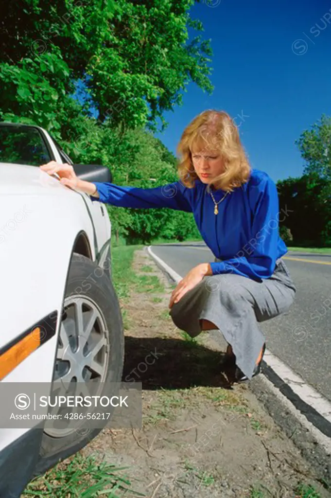 Woman changing a flat tire. 