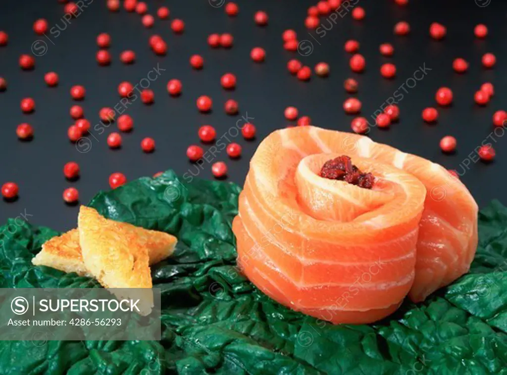 Close-up of fresh salmon roll with spinach and peppercorns