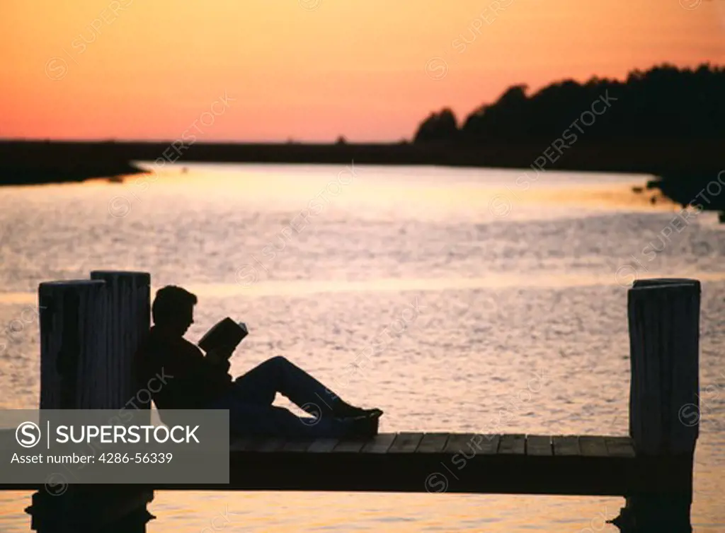 Person reading on a pier