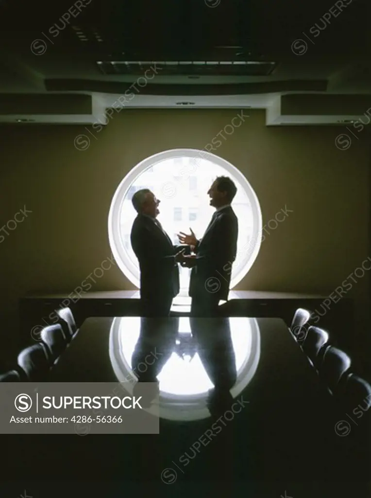 Two businessmen talking in a confrerence room