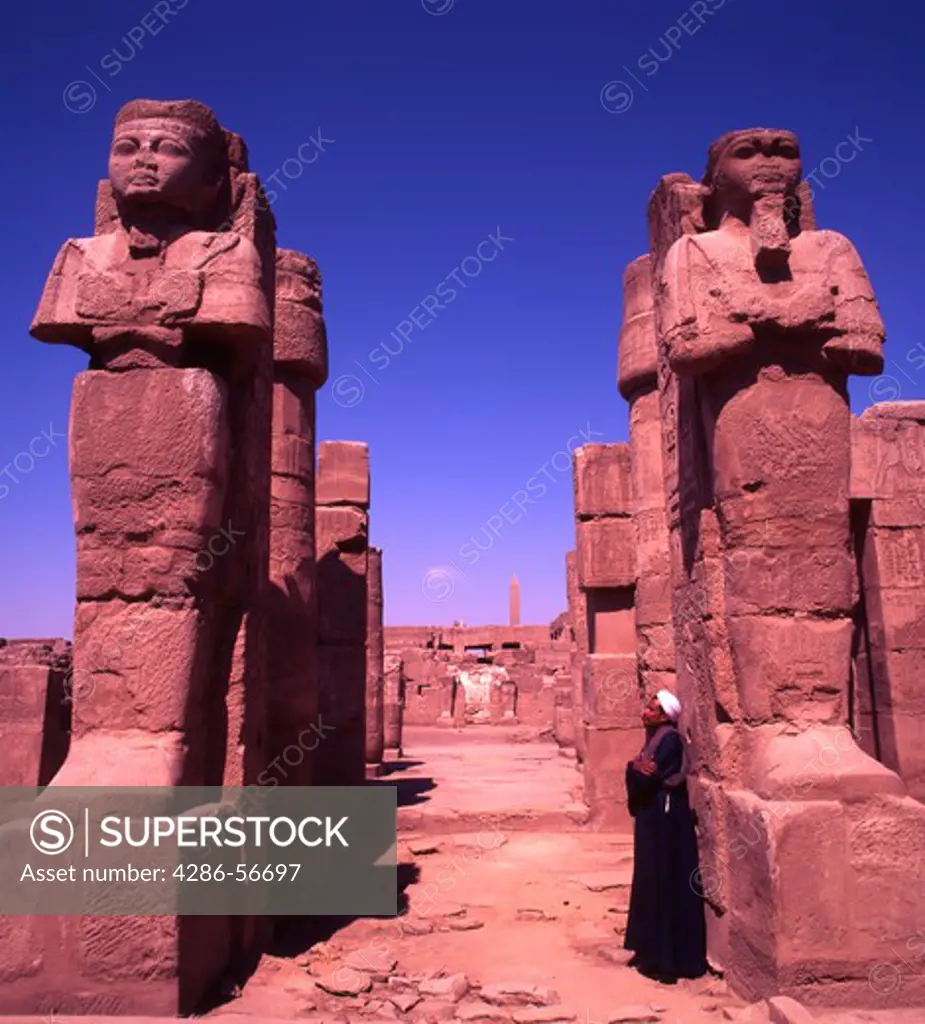 Egyptian Guide looking at Statues of Ramses One and Two. Karnak Temple. Luxor. Egypt.