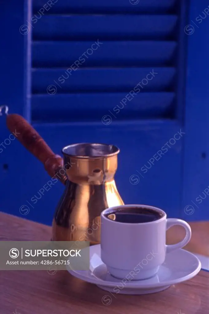 A cup of strong greek coffee, plus copper coffee pot.  Crete. Greece
