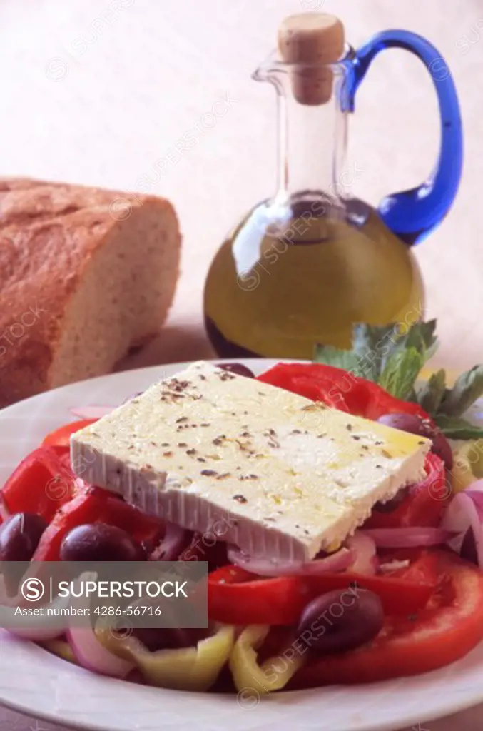 A Fresh Greek Salad (Horiatiki) and small bottle of Cretan Olive Oil.  Crete. Greece.