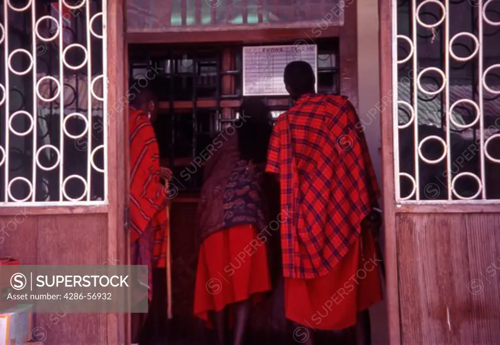 Three Masai Tribesmen exchanging foreign currency.  Stone Town, Zanzibar. Tanzania.