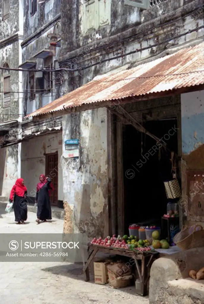 Zanzibar. Tanzania. East Africa. Two young Zanzibari women walking through the narrow streets of Stone Town.