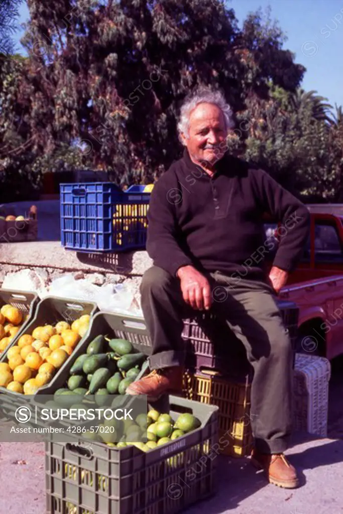 Greece. Western Crete. Rethymnon Street Market.  Cretan man selling fresh vegetables from the back of his pick up truck.