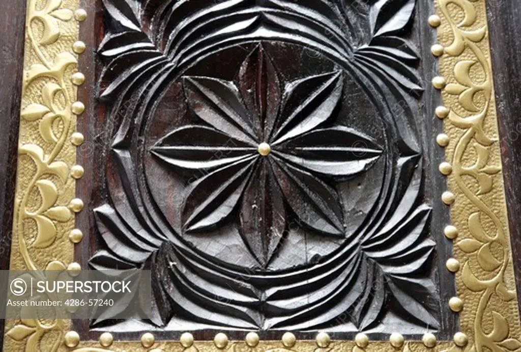 Zanzibar. Tanzania. Detail of hand carved antique wooden chest inlayed with Brass