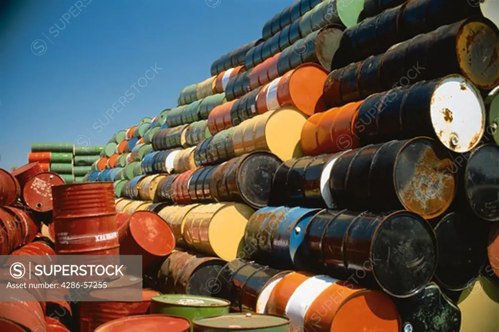 Stock pile of many, multicolored oil drums. 