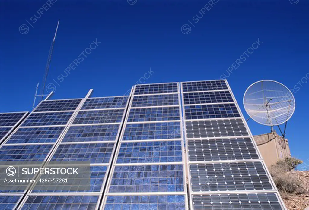 View of communication and solar panels on a day with very blue skies. 