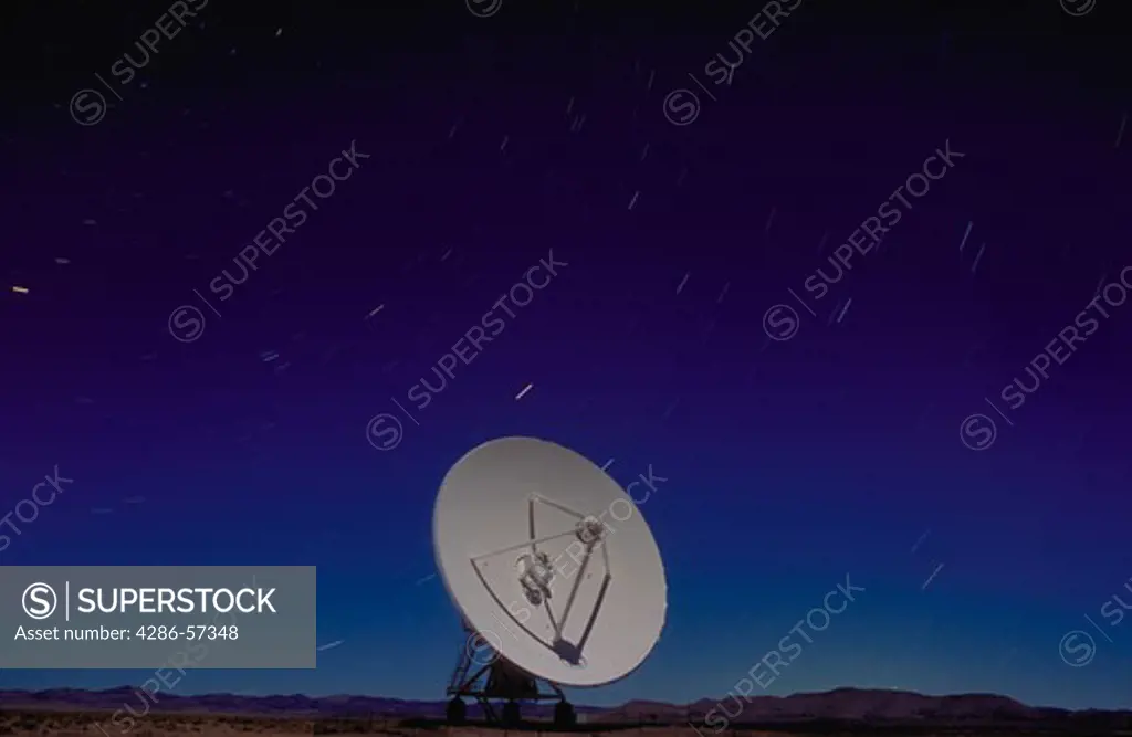 A radio telescope with stars moving in the background.