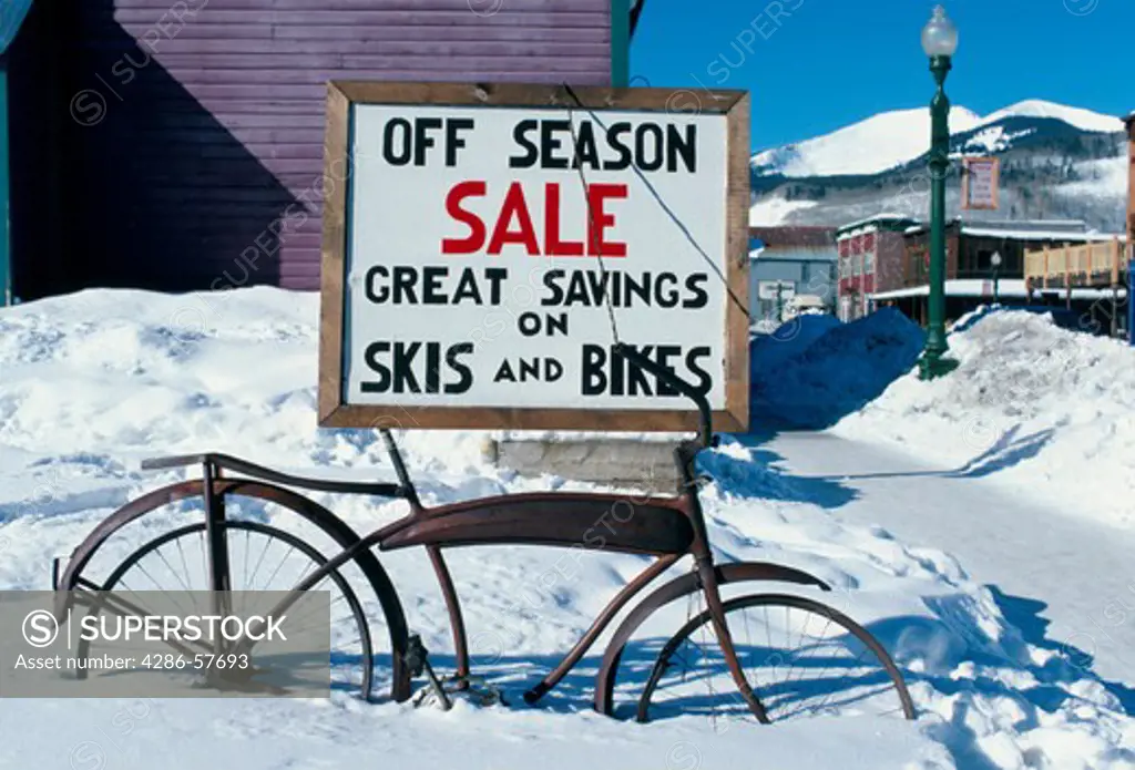 Store sign for skis and bikes  covered by snow in Crested Butte, CO.  