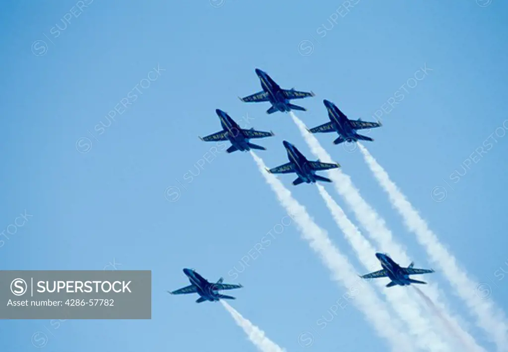 The U.S. Navys Blue Angels performing maneuvers flying against the blue sky.