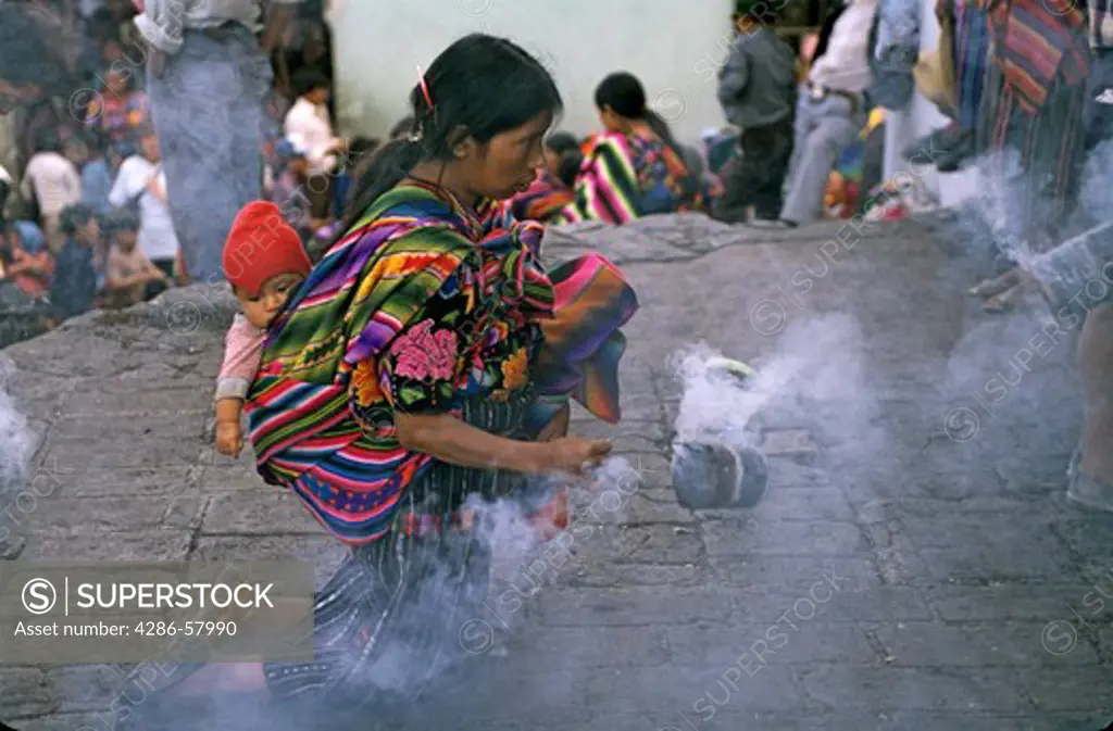 Approaching church of Santo Tomas on her knees and swinging burning incense, a Maya woman carries her baby on her back, Chichicastenango, Guatemala, Central America  Approaching church of Santo Tomas on her knees and swinging burning incense, a Maya woman carries her baby on her back, Chichicastenango, Guatemala, Central America