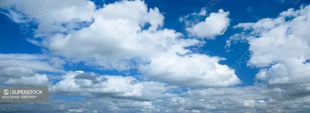 Cumulus clouds float in deep blue sky, Theodore Roosevelt National Park, North Dakota