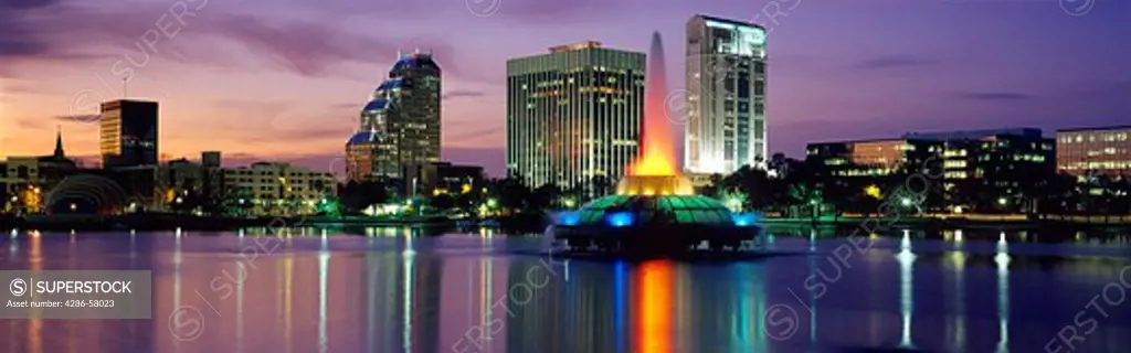 With glowing sunset as backdrop, downtown Orlando, FL, is reflected in mirror smooth Lake Eola.  With glowing sunset as backdrop, downtown Orlando, FL, is reflected in mirror smooth Lake Eola.