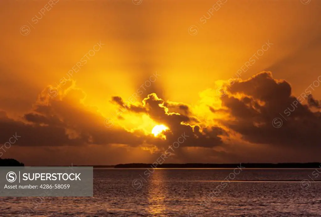 Rising sun burns through clouds above Florida Bay, Everglades National Park, Florida