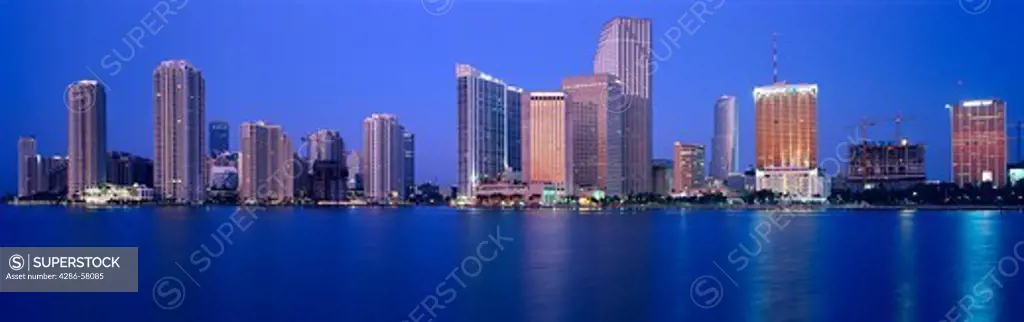 Just before a blue dawn, Biscayne Bay reflects high rise buildings, Miami, Florida.