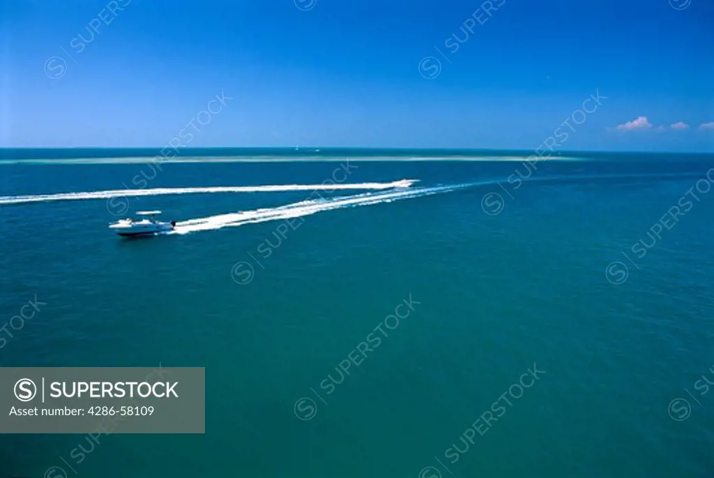 Pleasure boats cross as sky and water merge at Seven Mile Bridge, the Florida Keys, FL