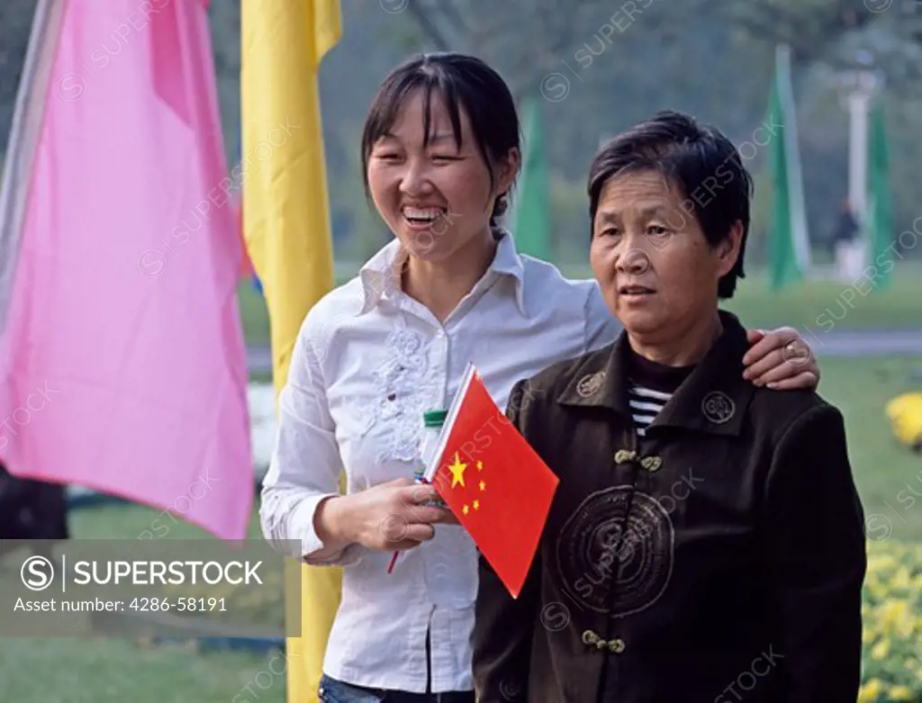 Grown daughter and mother pose for photograph in park during National Day holiday, Beijing, China