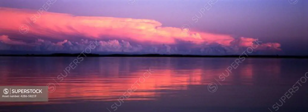 Lake reflects clearing summer rain storm burned red by setting sun, Big Pine Lake, East Otter Tail County, Minnesota