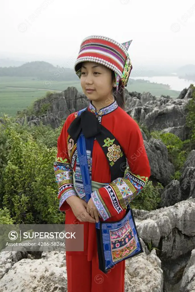 Young woman tour guide dressed in Sani ethnic minority costume, Naigu Stone Forest, Shilin, Yunnan Province, China. 