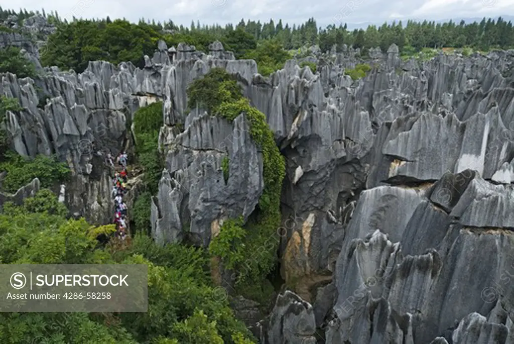 Visitors wind their way through towering Karst limesone formations that form the Stone Forest, Shilin, Yunnan Province, China.