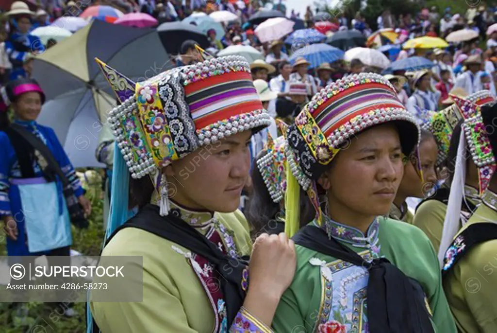 Young women dressed in traditional costumes of the Sani ethnic minority await their turn to perform at annual June Torch Festival in Long Lake Town, Shilin County, Yunnan Province, China.