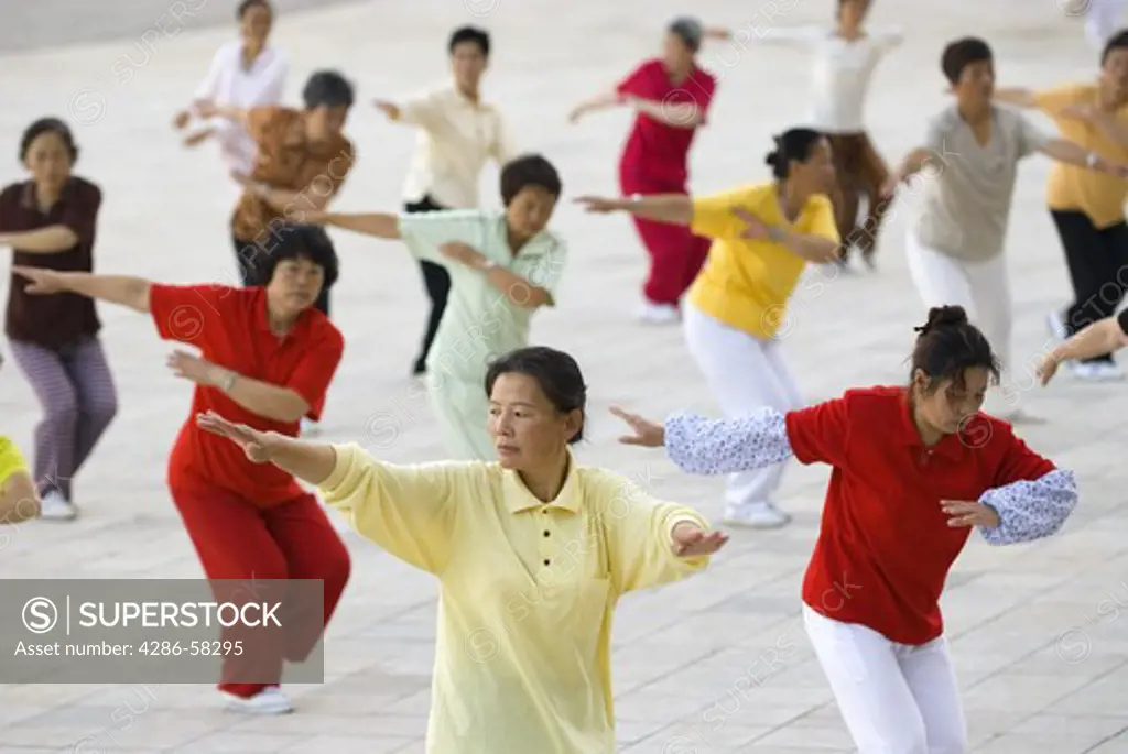 Middle aged women perform predawn taichi exercies in city park, Geju, Honghe County, Yunnan Province, China.