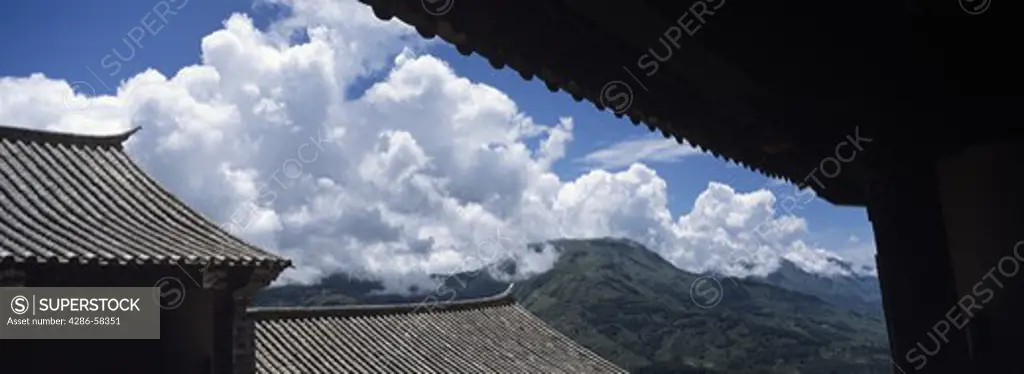 Undulating roof tiles outline the 270-year-old Meng Long Landlord's Home, now a guest house, high above the lush valleys of Yuan Yan County, Yunnan Province, China.