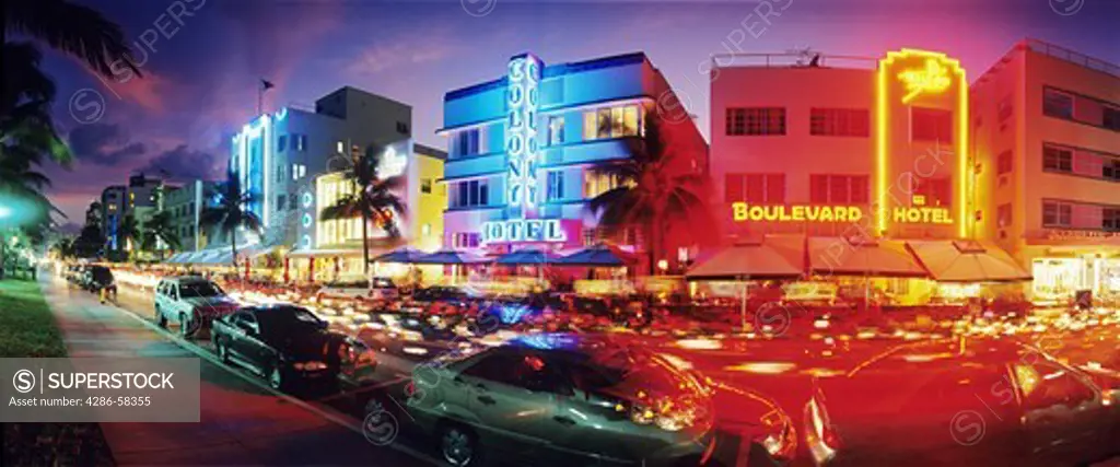 Glowing neon accents art deco era hotels along Ocean Drive at twilight, Miami Beach, Florida.