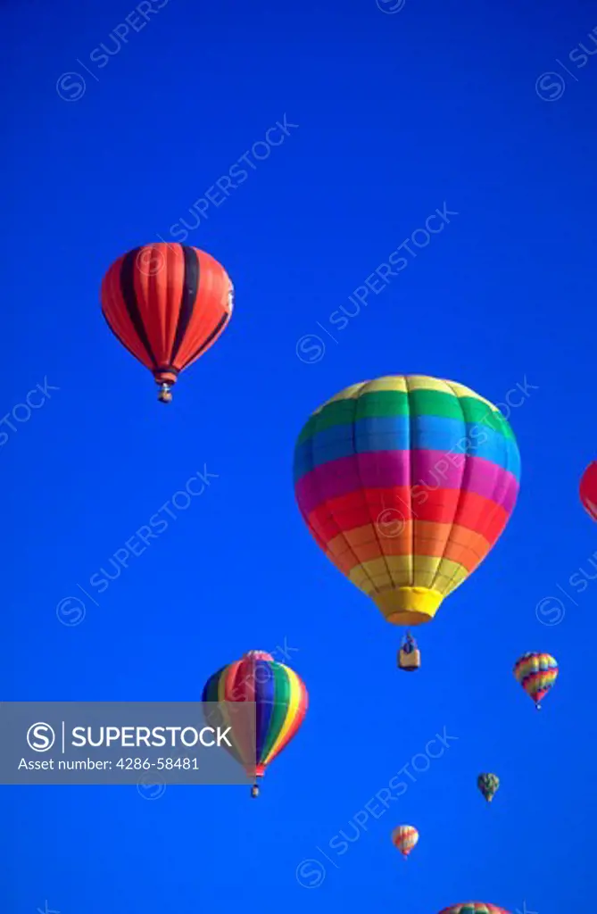 Colorful hot air balloons against a blue sky background at the Albuquerque Balloon Festival in Albuquerque, New Mexico.