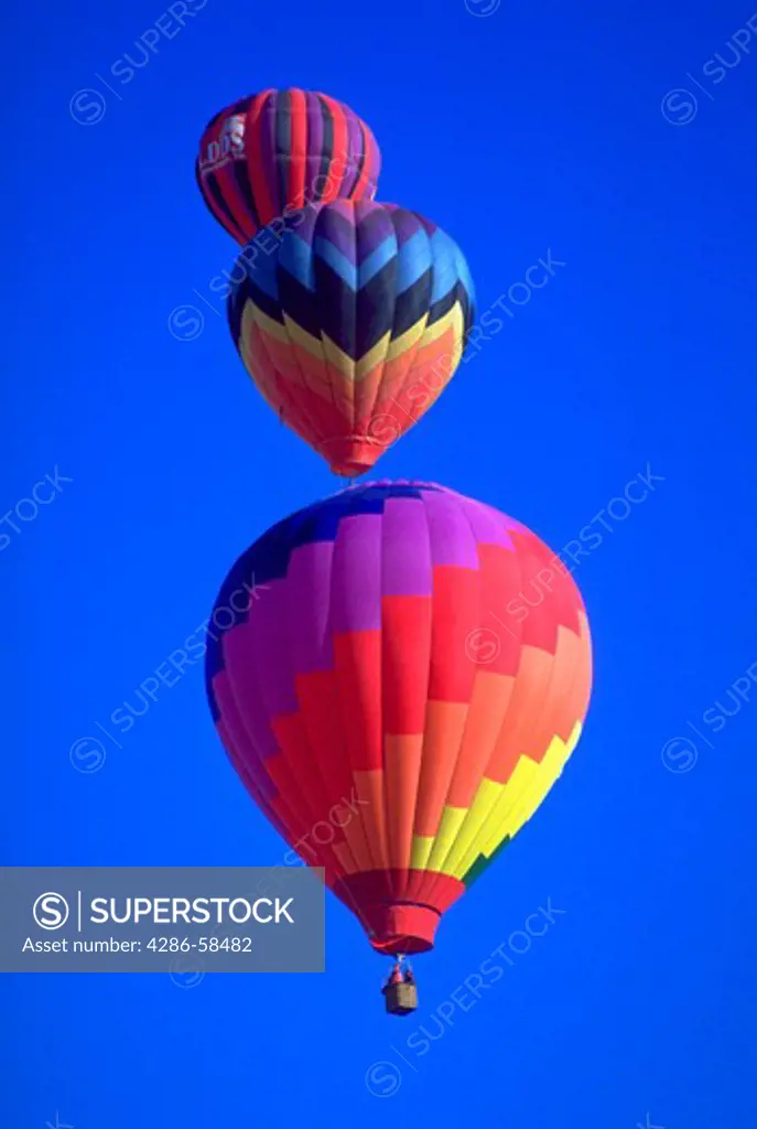Colorful hot air balloons against a blue sky background at the Albuquerque Balloon Festival in Albuquerque, New Mexico.