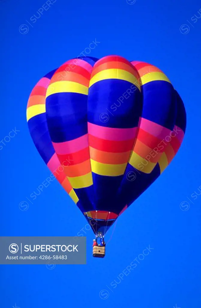A colorful hot air balloon against a blue sky background at the Albuquerque Balloon Festival in Albuquerque, New Mexico.