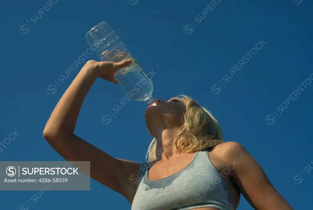 Athletic woman drinking bottled water.