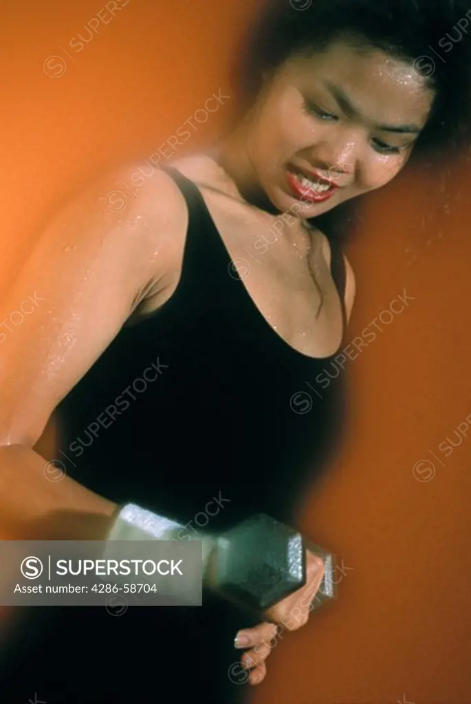 Asian woman exercising with weights.
