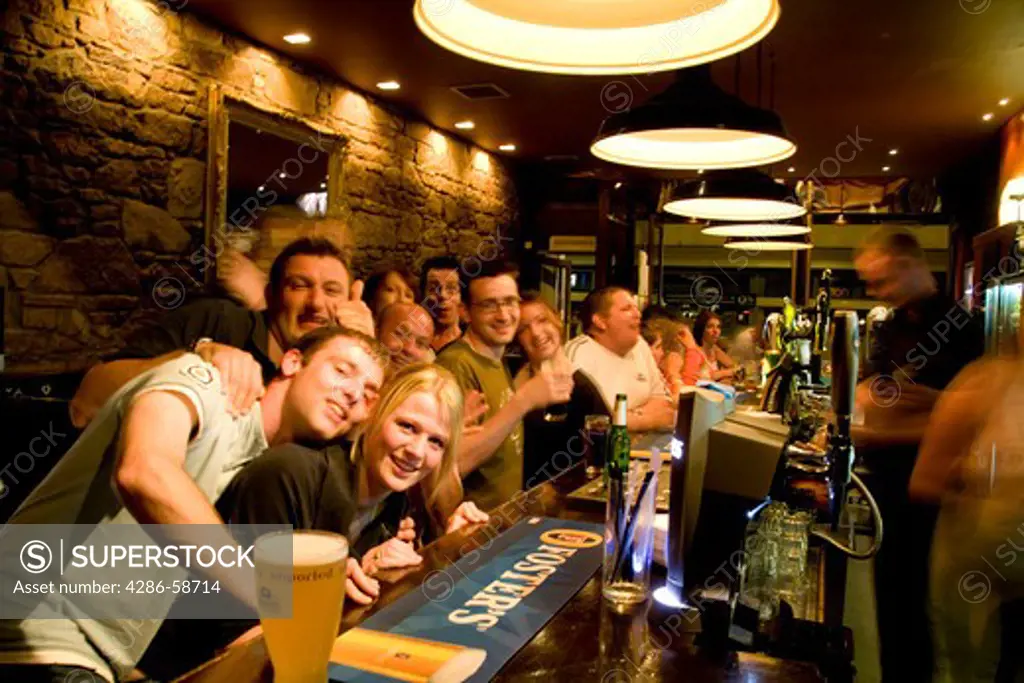 Happy young people at the Bar on Queens Gate Street in the quaint town of Inverness Scotland in the Highlands home of the Loch Ness Monster.