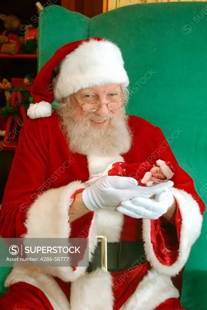Santa holds baby.
