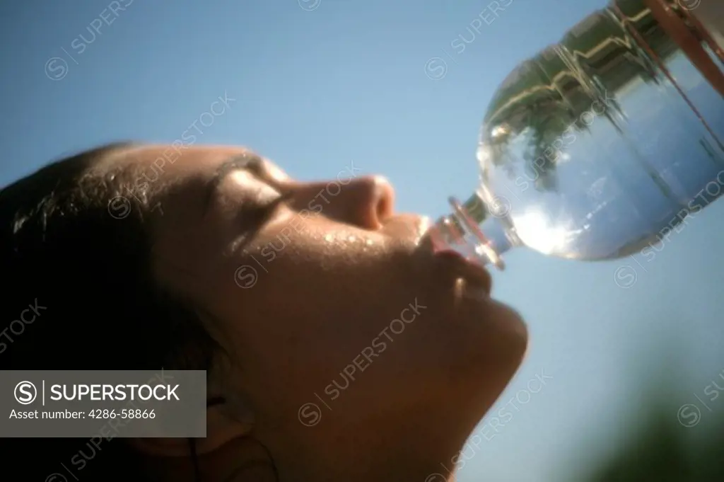 Woman athlete drinking bottled water