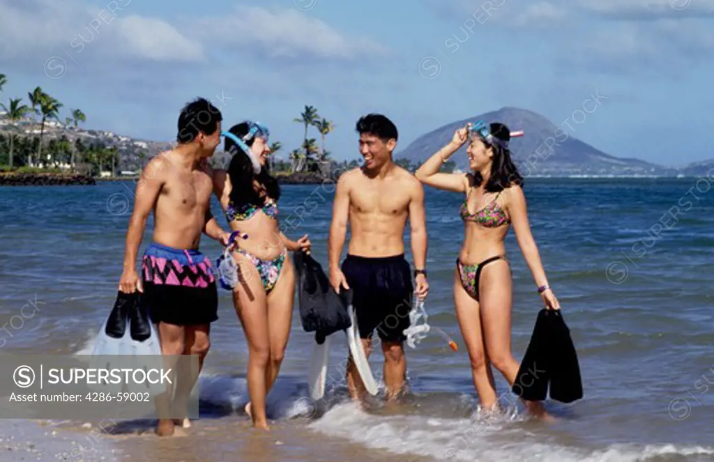 Japanese snorklers on vacation in Hanauma Bay in Hawaii with all gear