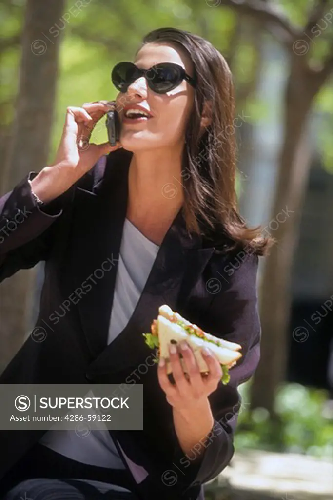 Business woman on lunch break talks on mobile phone.