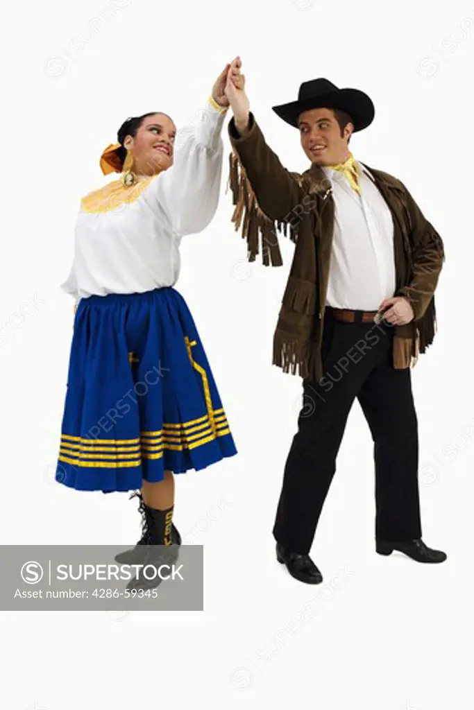 Young couple in typical Mexican costume and dancing