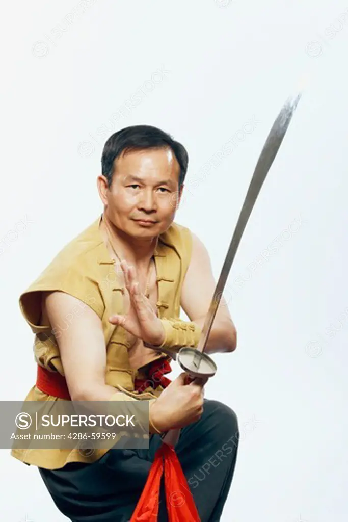 Portrait of a mature man practicing martial arts with a sword