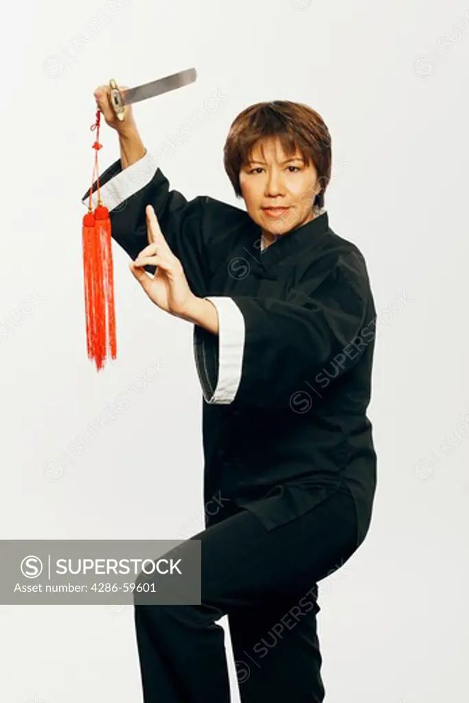 Portrait of a mature woman practicing martial arts with a sword