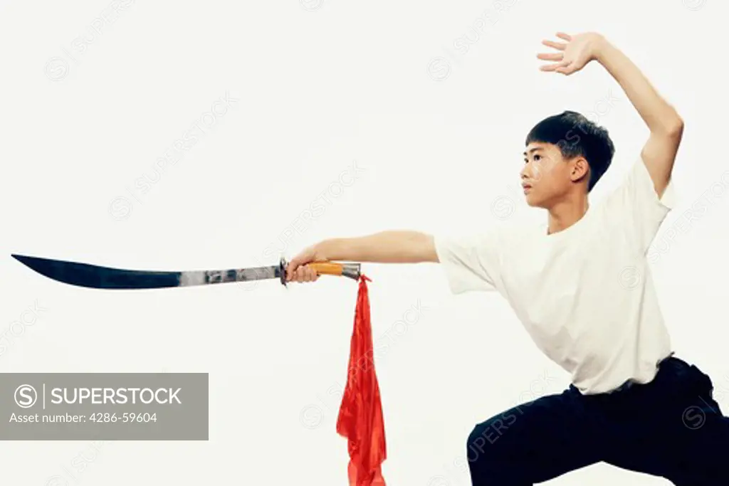 Boy practicing martial arts with a sword