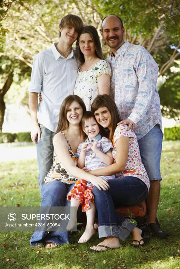 Portrait of a couple with their son and daughters in a lawn